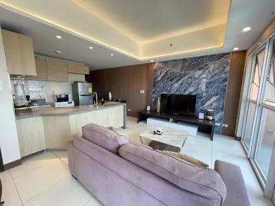 a living room with a couch and a kitchen at Venice Luxe Suite, 1 Bedroom Maximum, 4 adults plus kids in Manila