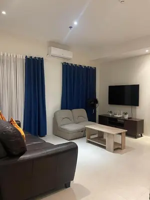 a living room with a couch and a flat screen tv at Condotels by Tribecca Private in Manila