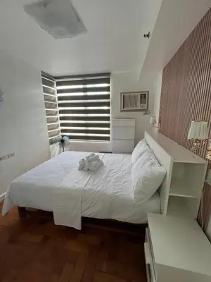 a bedroom with a white bed and a window at Antel Spa Residences 2509 in Manila
