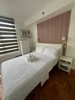 a bedroom with a white bed with two towels on it at Antel Spa Residences 2509 in Manila