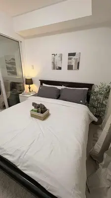 a white bed with a basket on top of it at Vacation Home MOLUAN in Manila