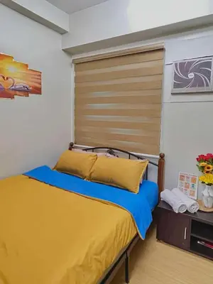 a bedroom with a bed with a wooden headboard at Vacation Home MOLUAN in Manila
