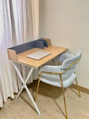 a wooden desk with a laptop and a chair at Manhattan Plaza Suite 1BR with City View, Netflix and Pool Access in Manila
