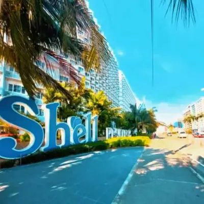 a sign in front of a building with a tennis court at 232 1br big balcony 2 queen size 1-sofa bed 1single extra mattress in Manila