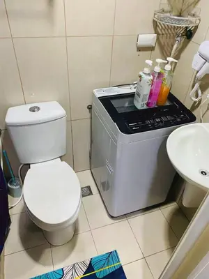 a small bathroom with a toilet and a sink at 232 1br big balcony 2 queen size 1-sofa bed 1single extra mattress in Manila