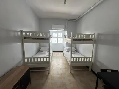a room with three bunk beds and a table at Overnight sleeps in Manila