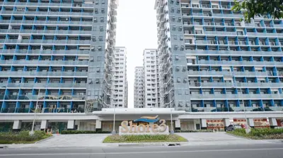 a building with a sign in front of two tall buildings at SM MOA Near NAIA Airports 1 Bedroom with balcony SG Suite 2 at Shore 3 in Manila