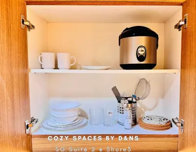 a cupboard with a coffee pot and dishes on it at SM MOA Near NAIA Airports 1 Bedroom with balcony SG Suite 2 at Shore 3 in Manila