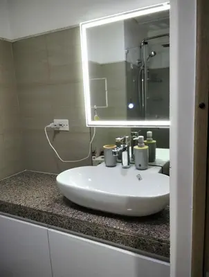 a bathroom with a white sink and a mirror at Urban Haven at Shore Residences Near MOA in Manila