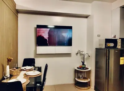 a dining room with a table and a refrigerator at Urban Haven at Shore Residences Near MOA in Manila