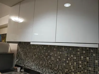 a white cabinet above a sink in a kitchen at Urban Haven at Shore Residences Near MOA in Manila