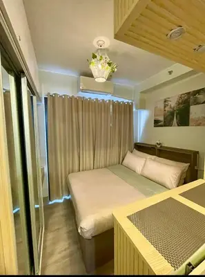 a small bedroom with a bed and a window at R Cabin - Shore Residences in Manila