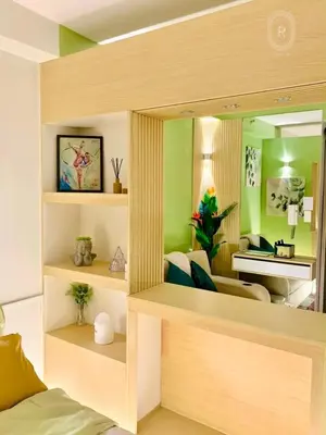 a living room with green walls and a bed and a mirror at R Cabin - Shore Residences in Manila