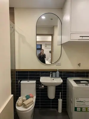 a person taking a picture of a bathroom with a mirror at Vacation in Cupang Muntinlupa in Manila