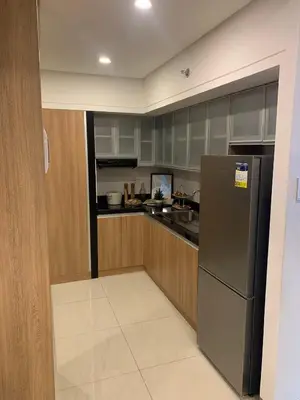 a kitchen with a stainless steel refrigerator and wooden cabinets at Vacation in Cupang Muntinlupa in Manila