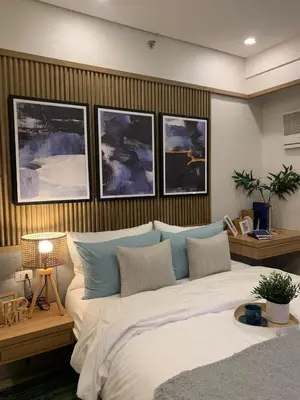 a bedroom with a large bed with paintings on the wall at Vacation in Cupang Muntinlupa in Manila