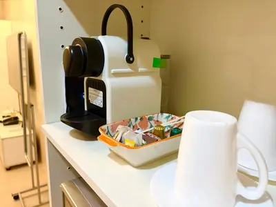 a kitchen counter with a coffee maker and a tray of food at Unit 2H 81 Newport Boulevard Condominium Perfect for Layovers Across NAIA Terminal 3 in Manila