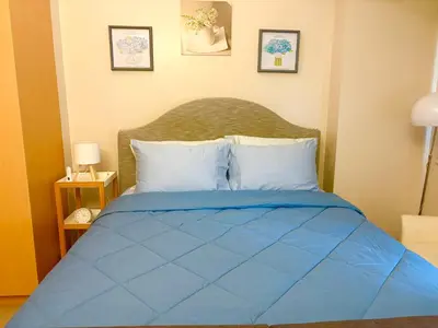 a bed with a blue comforter in a bedroom at Unit 2H 81 Newport Boulevard Condominium Perfect for Layovers Across NAIA Terminal 3 in Manila