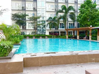 a large swimming pool in front of a building at Unit 2H 81 Newport Boulevard Condominium Perfect for Layovers Across NAIA Terminal 3 in Manila