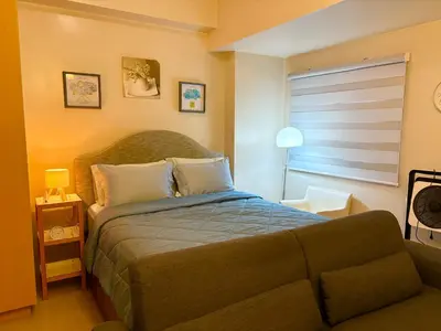 a bedroom with a large bed and a window at Unit 2H 81 Newport Boulevard Condominium Perfect for Layovers Across NAIA Terminal 3 in Manila
