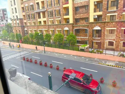 a red car parked on the side of a street at Unit 2H 81 Newport Boulevard Condominium Perfect for Layovers Across NAIA Terminal 3 in Manila