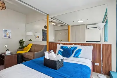 a bedroom with a bed and a couch at BGC High Rise, Uptown Mall Link, 5G WiFi, Pool, Ste 19 in Manila