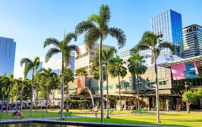 a park with palm trees in front of a building at BGC High Rise, Uptown Mall Link, 5G WiFi, Pool, Ste 19 in Manila