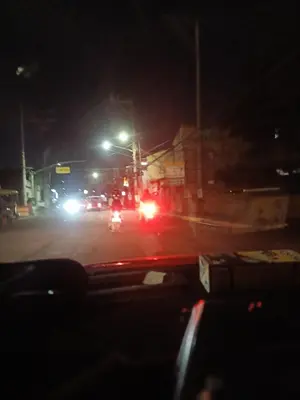 a car driving down a street at night at Dream hotel in Manila