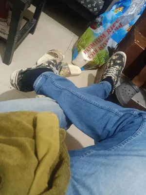 a person wearing shoes and jeans sitting on the floor at Dream hotel in Manila