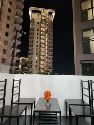 two tables and chairs with buildings in the background at Azure Residences 1 Bedroom with Wide Balcony in Manila