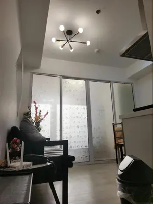 a living room with a couch and a ceiling fan at Azure Residences 1 Bedroom with Wide Balcony in Manila