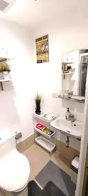 a bathroom with a sink and a toilet and a mirror at Move In Condo in Taguig Fully Furnished in Manila