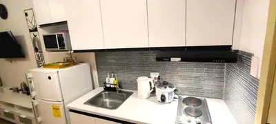 a small kitchen with a sink and a refrigerator at Move In Condo in Taguig Fully Furnished in Manila