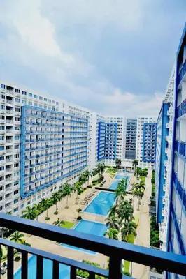 an apartment balcony with a swimming pool and buildings at Sea Residences - Casa Juana at Mall of Asia in Manila