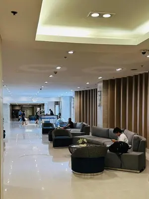 a lobby with people sitting on couches in a building at Sea Residences - Casa Juana at Mall of Asia in Manila