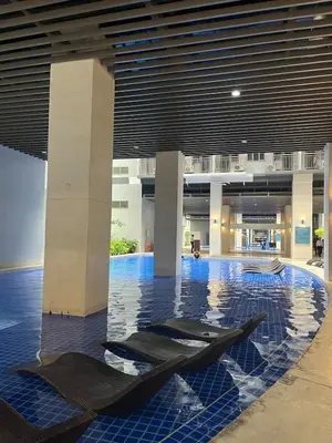 a lobby with a pool with two sculptures in it at Cozy Family and Group-Friendly Private 2 Bedroom with Coffee Bar and Fast Wifi at S Residences Mall of Asia in Manila