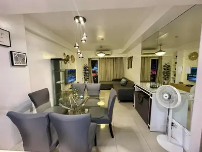 a dining room and living room with a table and chairs at Shell Residence 2 bedroom by Kathy in Manila