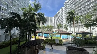 a person walking down a walkway in a building at Shell Residence 2 bedroom by Kathy in Manila