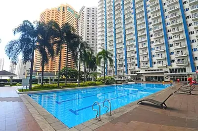 a large swimming pool in front of tall buildings at 1 BR Boni LIGHT Condo WIFI Netflix Pool Balcony in Manila