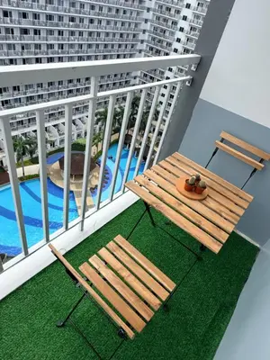 a balcony with a table and chairs and a pool at The Nox Suites in Manila