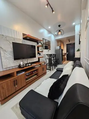 a living room with a couch and a flat screen tv at Near NAIA Mediterranean Cozy Home with Netflix in Manila