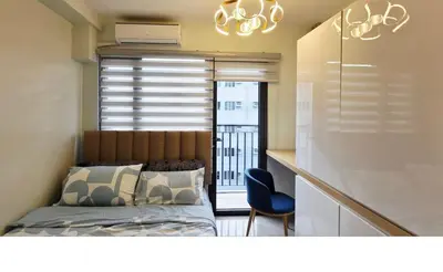 a bedroom with a bed and a desk with a chair at Executive Saver Suite 1BR Mall of Asia Airport in Manila