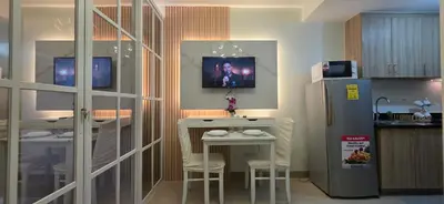 a kitchen with two tables and a refrigerator at Executive Saver Suite 1BR Mall of Asia Airport in Manila