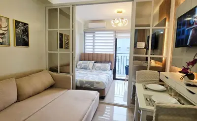 a living room with a couch and a bed at Executive Saver Suite 1BR Mall of Asia Airport in Manila