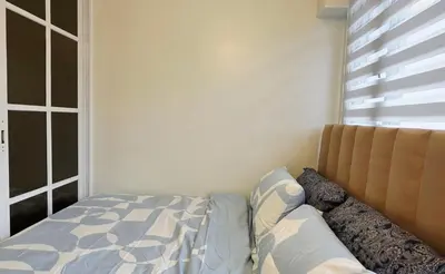 a bedroom with a bed and a window at Executive Saver Suite 1BR Mall of Asia Airport in Manila