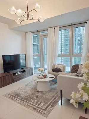 a living room with a couch and a tv at Uptown BGC Residences by ChiKat in Manila