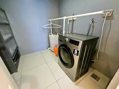 a washer and dryer in a small bathroom at Uptown BGC Residences by ChiKat in Manila