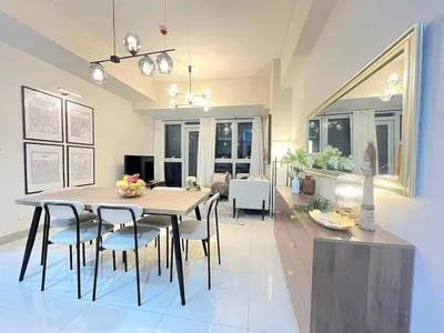 a dining room and living room with a table and chairs at Uptown BGC Residences by ChiKat in Manila