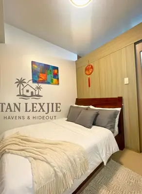 a bedroom with a bed with a sign on the wall at Shore Residences by Tan LexJie in Manila