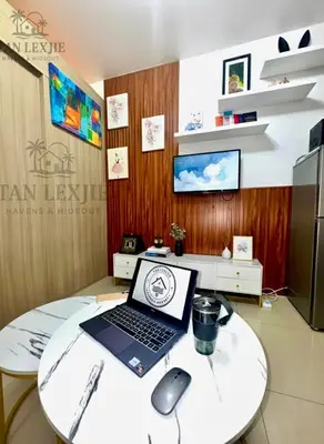 a laptop on a round table with a mouse at Shore Residences by Tan LexJie in Manila